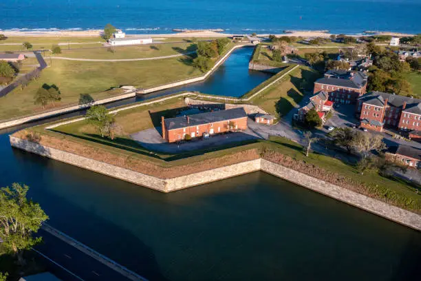 Wall and Earthen Bastion at Fort Monroe With a Building Behind the Fortress and Bay in the Background