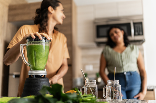 Couple preparing detox juice in kitchen at home