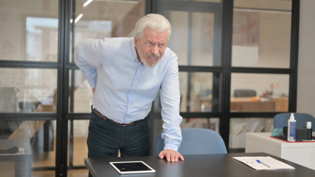 istock Old Businessman having Back Pain while Standing in Office 1831179324