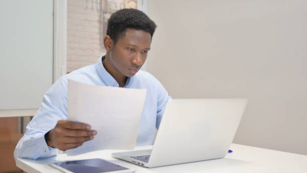 istock African Businessman Working on Documents and Laptop 1831181585