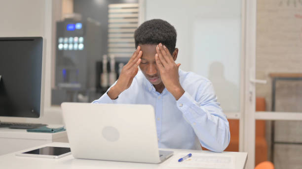 istock African Businessman having Headache at Work 1831198007