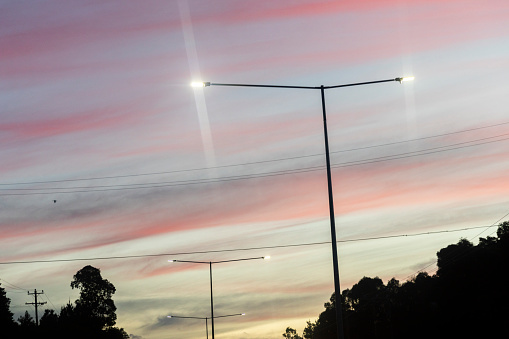 Streetlights in the urban landscape stand against the beautiful dusk sky.