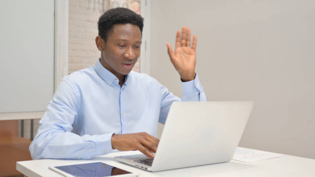 istock African Businessman Chatting Online on Laptop while Sitting in Office 1831214745