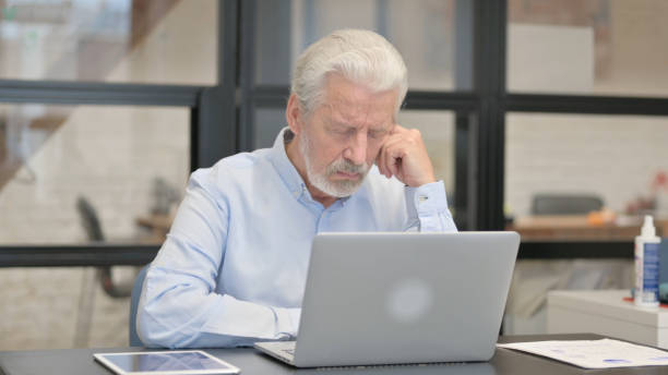 istock Tired Old Businessman Sleeping in Office 1831237699