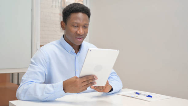 istock African Businessman Doing Video Chat on Tablet in Office 1831249420