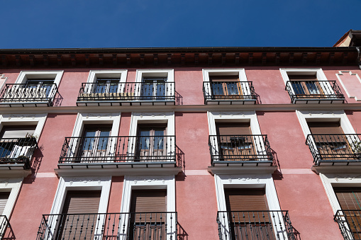Pink buildings with balconies in downtown Madrid , Spain