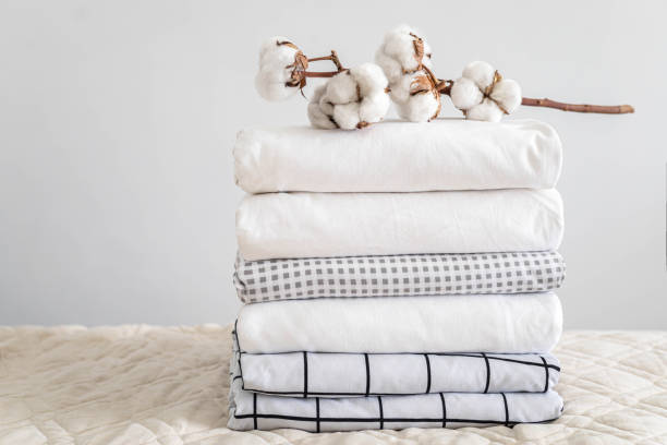 istock Cotton branch with pile of folded bed sheets and blankets 1831263004