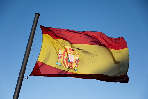 Backlit Spanish flag at sunset in Madrid, Spain