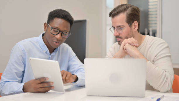 istock African Businessman Discussing Work with Business Partner 1831267239