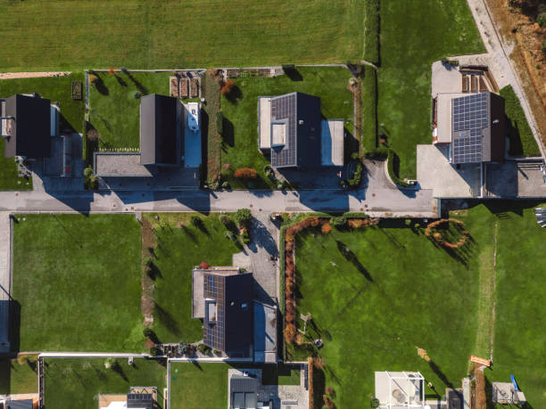 istock Low aerial close view new dense rural housing development, mostly grey roofing, some green landscaping, young trees. Modern homes with flat roof 1831282483