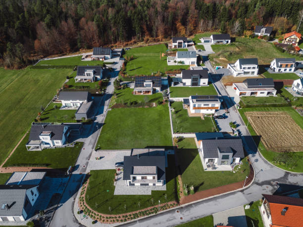 istock Low aerial close view new dense rural housing development, mostly grey roofing, some green landscaping, young trees. Modern homes with flat roof 1831282578
