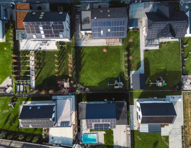 istock Low aerial close view new dense rural housing development, mostly grey roofing, some green landscaping, young trees. Modern homes with flat roof 1831282583