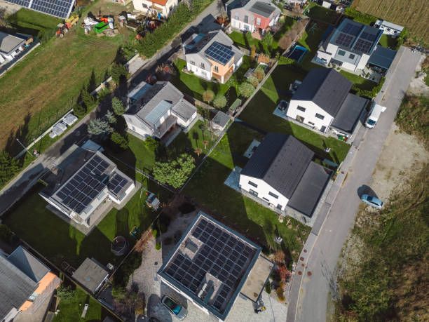 istock Low aerial close view new dense rural housing development, mostly grey roofing, some green landscaping, young trees. Modern homes with flat roof 1831283108