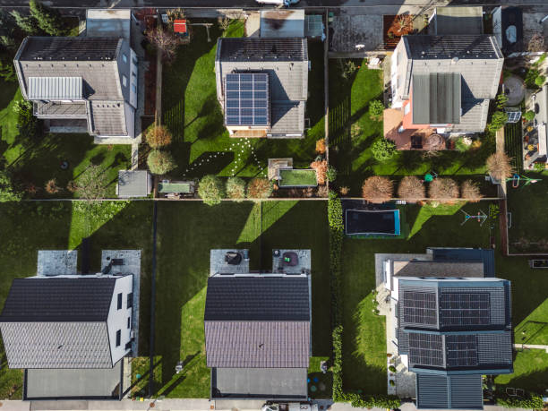 istock Low aerial close view new dense rural housing development, mostly grey roofing, some green landscaping, young trees. Modern homes with flat roof 1831283113