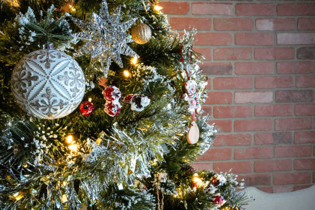 istock christmas tree with garland, baubles ornament against a red brick wall 1831318575