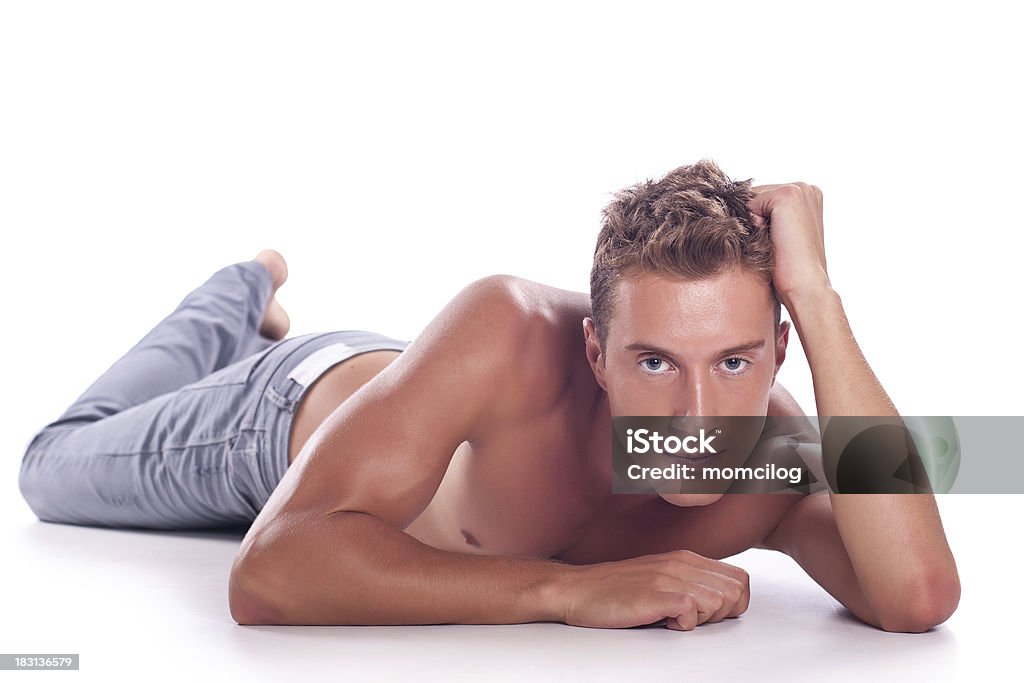 Male beauty Attractive male laying shirtless and looking straight in the camera. Selective focus on eyes Lying Down Stock Photo