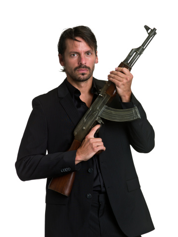 Hispanic mid adult man posing holding a MK 47 assault rifle on white background (this picture has been taken with a super high definition Hasselblad H3D II 31 megapixels camera)