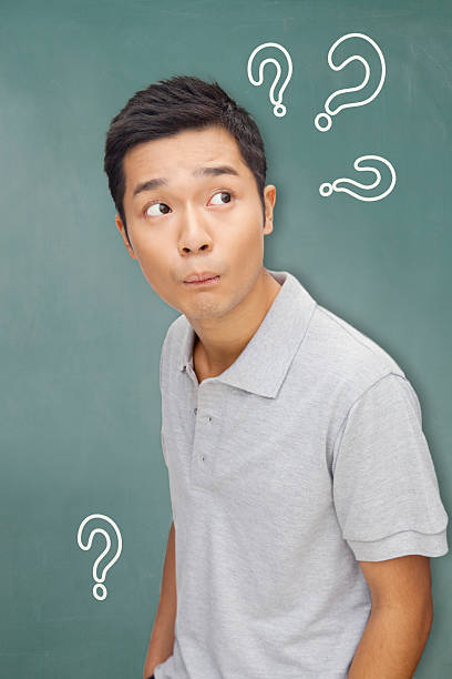 istock Portrait young man in front of blackboard with question marks 183136815