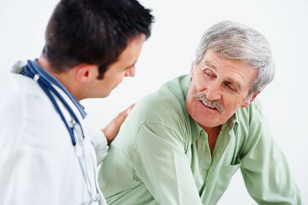 istock Male doctor comforting an elderly man against white 183137773