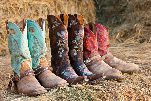 tres par de botas de vaquero siéntese en heno - cowboy boot embroidery haystack buckle fotografías e imágenes de stock