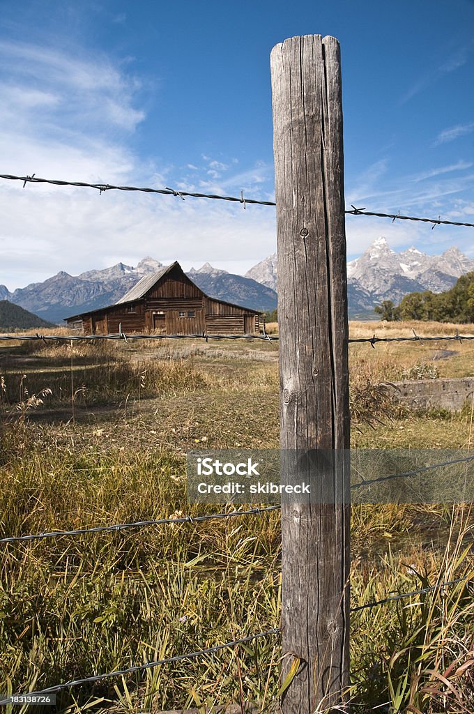 Mormon Barn e Grand Tetons visto através de Muro - Foto de stock de Coluna de Madeira royalty-free