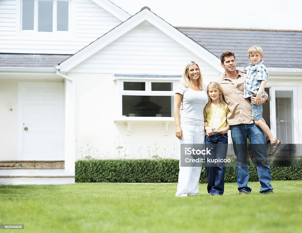 Medio invecchiato coppia in piedi con i bambini al di fuori del loro casa - Foto stock royalty-free di Famiglia