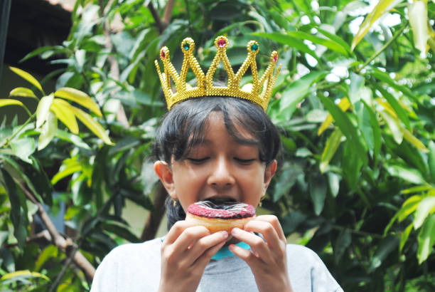 istock Happy girl eats a donut. 1831410424