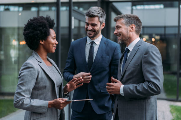 istock Business people talking outside of office building. 1831418606