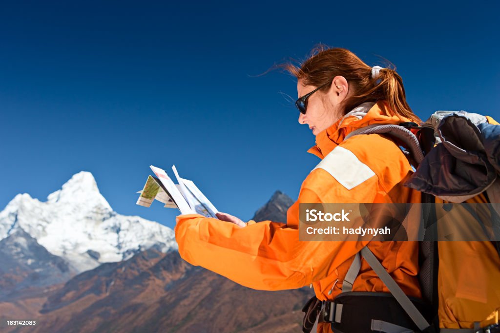 Trekking femmina studiando una mappa, Monte Ama Dablam sullo sfondo - Foto stock royalty-free di Adulto