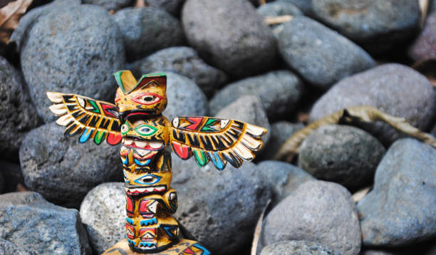 mât totémique en fond de pierres. - north american tribal culture photography color image horizontal photos et images de collection