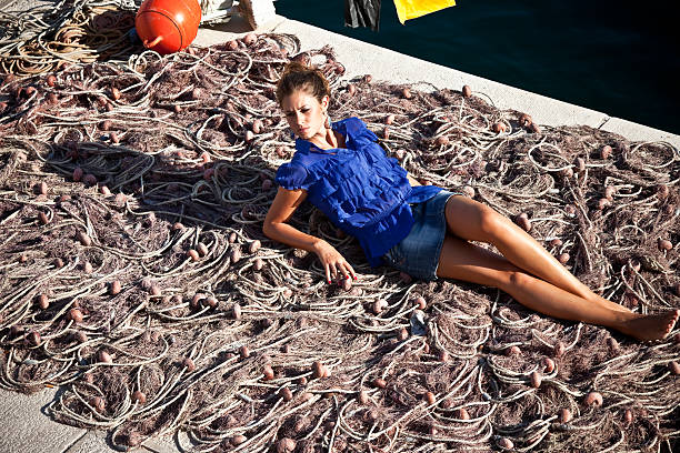 20er sexy mädchen liegen auf fishing net - beautiful boredom sensuality desire stock-fotos und bilder