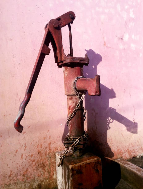 village tube well A village tube well or water pump on the roadside. old fashioned well hand pump stock pictures, royalty-free photos & images