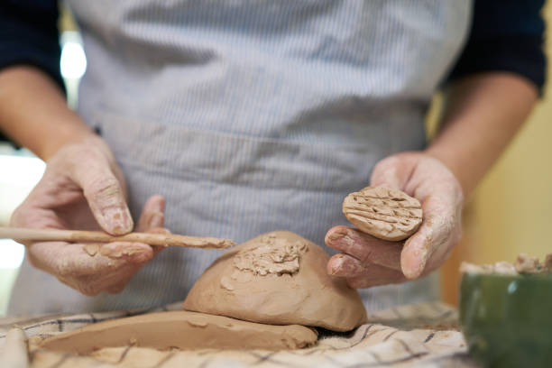 istock woman forming clay pot shape by hands, closeup in artistic studio 1831515057