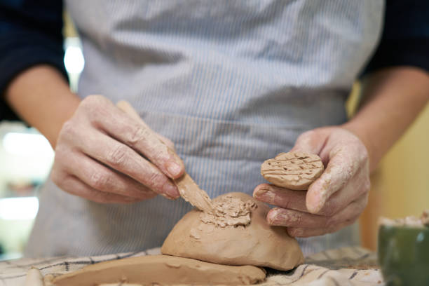 istock woman forming clay pot shape by hands, closeup in artistic studio 1831515059
