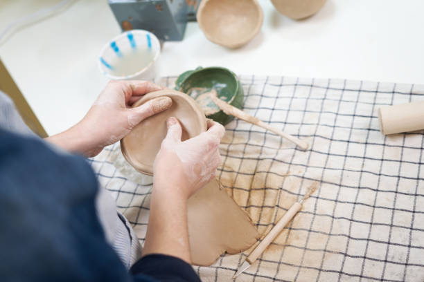 istock woman forming clay pot shape by hands, closeup in artistic studio 1831515063