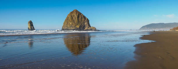 istock Cannon Beach Oregon Coast Haystack Rock Surf Sand Panorama 1831521308