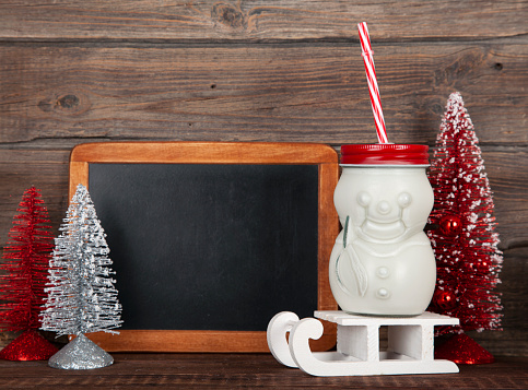 Blackboard with Christmas decoration on wood over rustic background with copy space for text