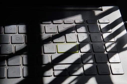 shadowy picture of laptop keyboard kept near window
