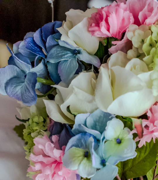 blue, pink, white, yellow and cream colored artifical flowers in a wedding bouquet - cut flowers white small still life imagens e fotografias de stock