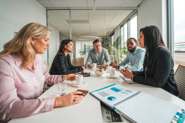 istock Mid Adult Multiracial Start Up Members at Conference Table 1831539337