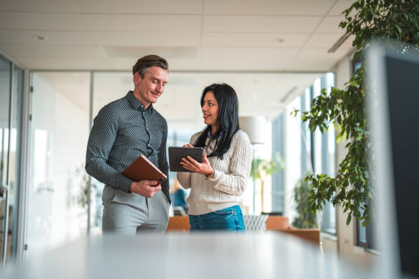 istock Latina Office Worker Chatting With Mid Adult Caucasian Manager 1831540890