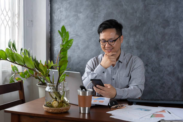 istock Confident smiling businessman using smartphone in a home office. Checking new emails. Inspiring productivity with a wealth of technology. 1831554105