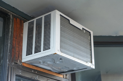 old air conditioner installed on old wood wall building
