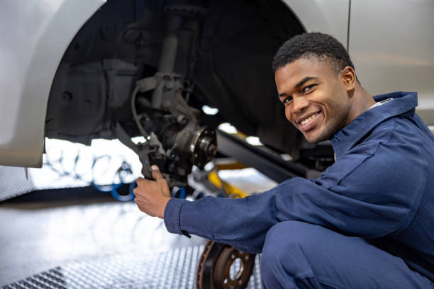 istock Happy mechanic fixing a flat tire at a car garage 1831594844