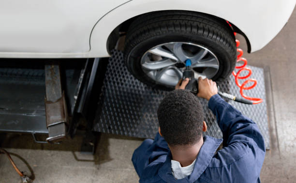 istock Mechanic changing a flat tire at an auto repair shop 1831594861