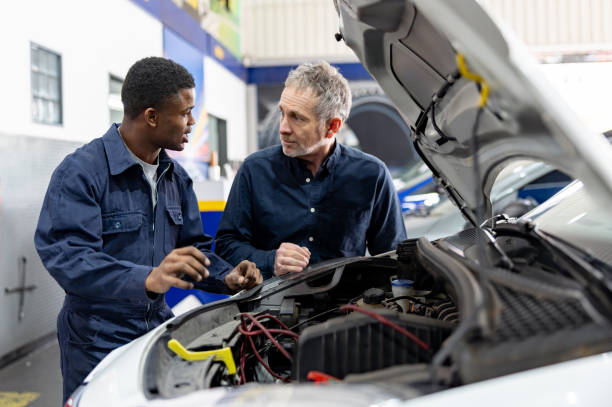 istock Mechanic talking to a client while fixing his car at a garage 1831594868