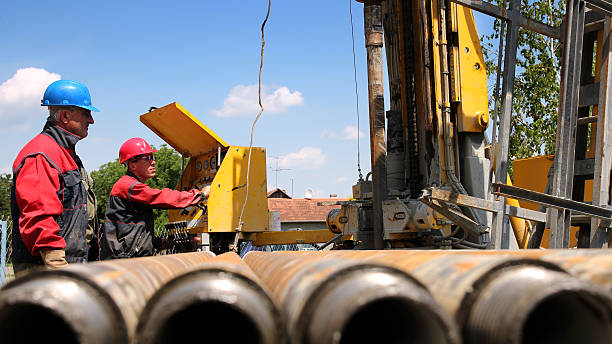 Oil and Gas Drilling Rig Oil drilling rig workers lifting drill pipe. drill team stock pictures, royalty-free photos & images