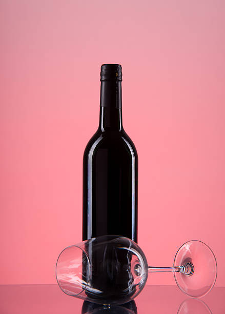 istock bottle with red wine and glass on a pink gradient 183165552