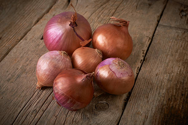 istock purple onions on wooden table 183166179