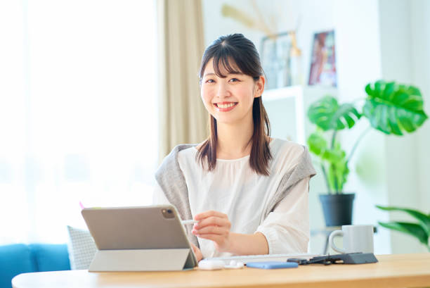 カジュアルな服装で働く若い女性 - 日本人 女性 ストックフォトと画像